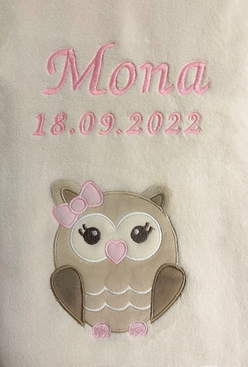 Morbidissima copertina per neonati color beige con ricamo rosa: nome Mona e data 18/09/2022. Sotto, una graziosa applicazione a forma di gufo, marrone chiaro con grandi occhi, naso a forma di cuore rosa e fiocco rosa. Morbida e avvolgente.