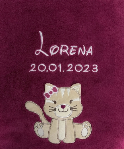 Copertina morbida per neonati color bacca con ricami bianchi. In alto il nome "Lorena" in caratteri eleganti, sotto la data di nascita "20.01.2023". In basso, gattino beige con fiocco rosa sull’orecchio, con baffi e zampe.